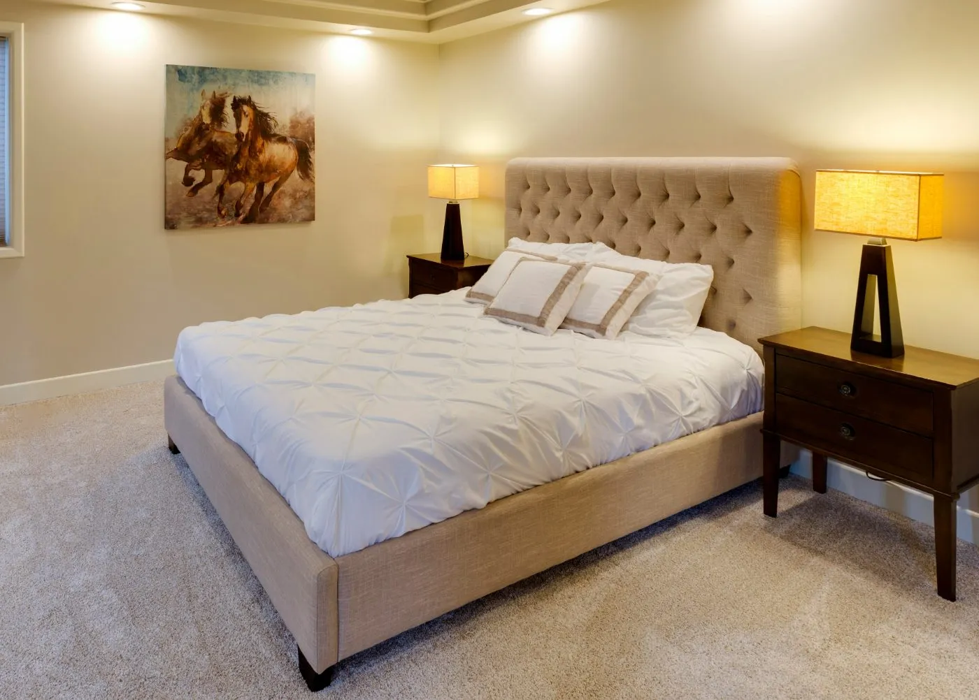 Wall-to-wall carpet in a warm bedroom with an upholstered bed and nightstands