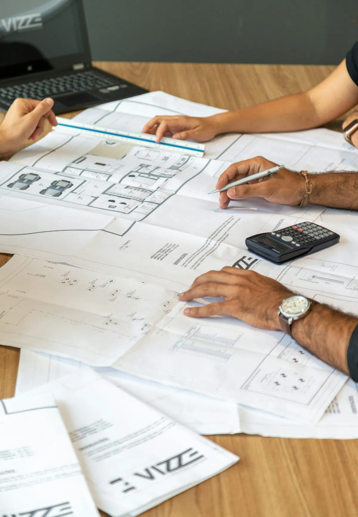 Project team reviewing floor plans and drawings at a table