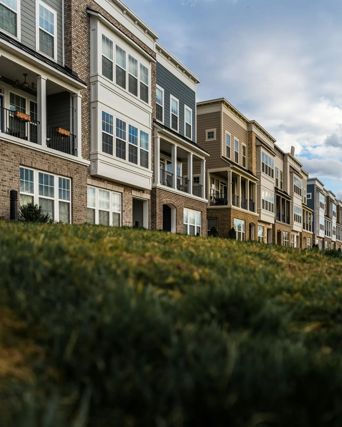 Row of new brick and siding townhomes under a blue sky
