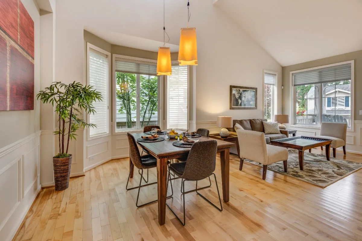 Light maple hardwood floor in a dining and living space with a table and seating
