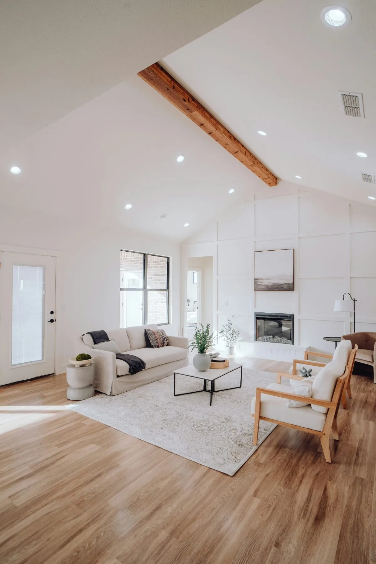 Wide-plank luxury vinyl flooring in a furnished living room with a fireplace