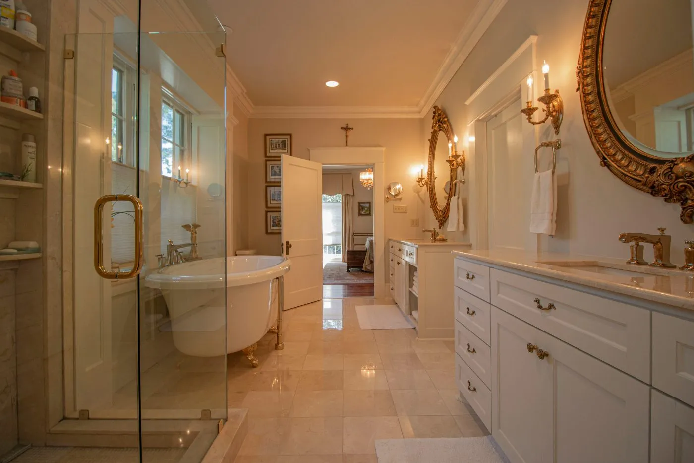 Polished stone tile floor in a traditional bathroom with a clawfoot tub and glass shower